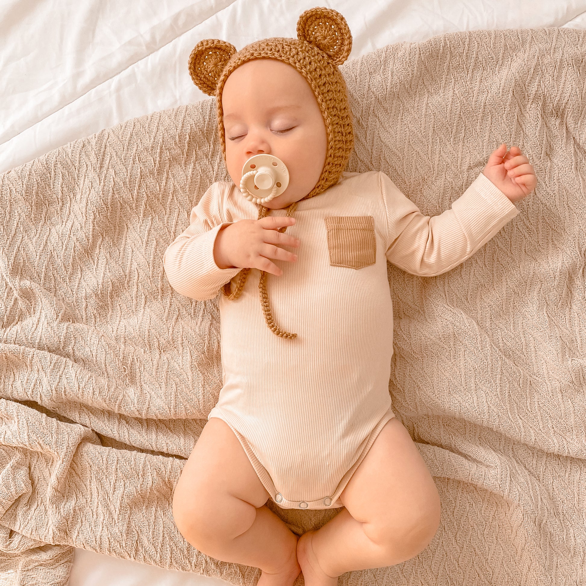 Nude ribbed baby romper, long sleeve. 